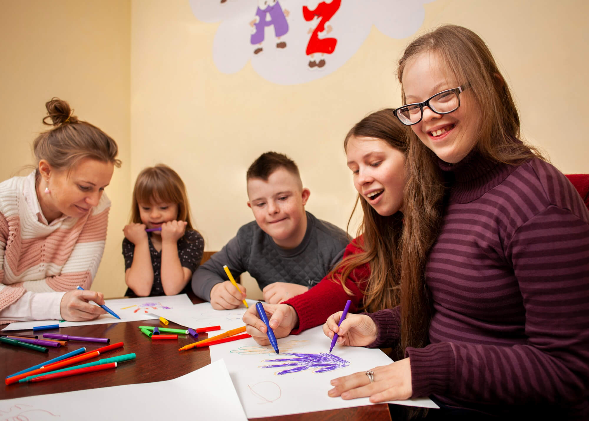 Happy girl with down syndrome posing while drawing