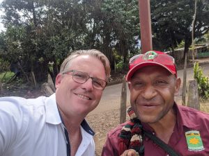 Ricky and his tour guide smile for the camera by the side of the road in Papua New Guinea.
